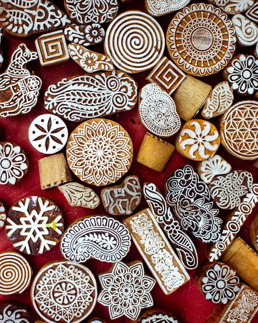 Conjunto de tacos de madera tallados con motivos ornamentales, colocados sobre una superficie de trabajo